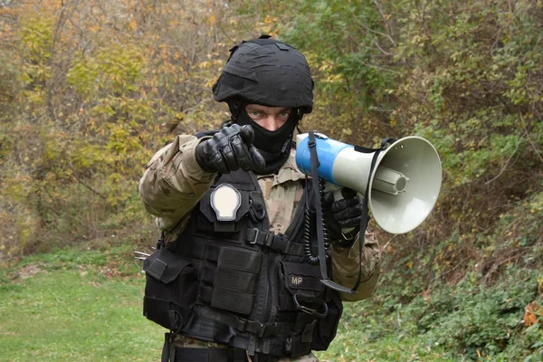 En politimann roper på en megafon: – stockfoto