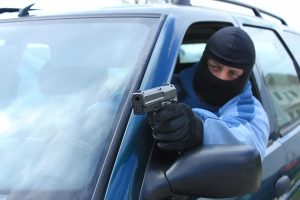 Assassin shooting from a moving car — Stock Photo, Image