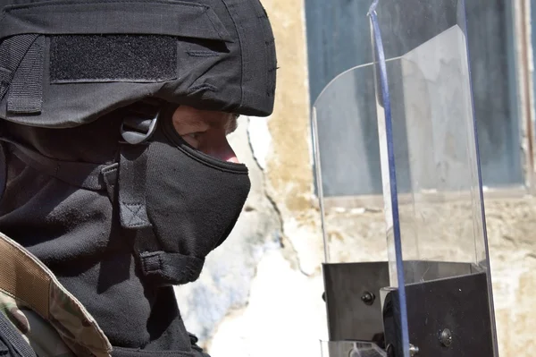 Policial em um capacete protetor e viseira, preparação para a manifestação — Fotografia de Stock