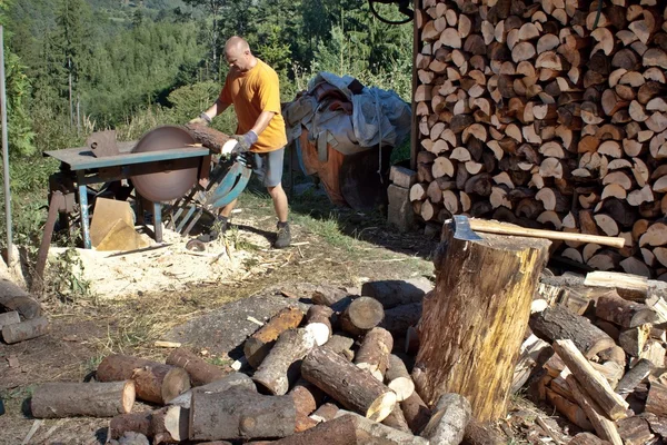 Homme coupant du bois de chauffage, se préparant pour l'hiver — Photo