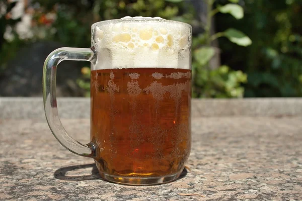 いっぱいぼやけて背景を森林にビールのグラス — ストック写真