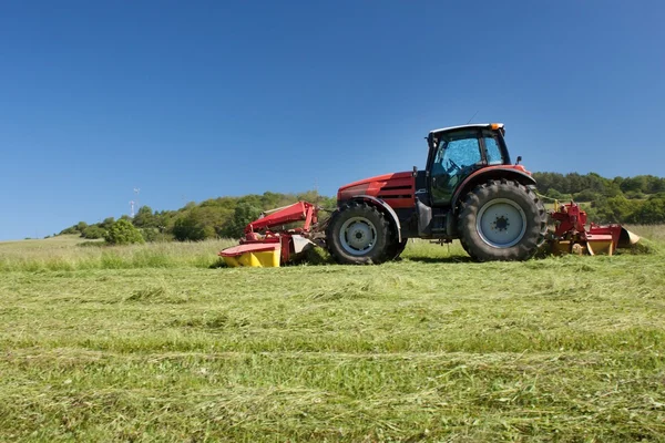 Traktor merah memotong padang rumput, musim panas, Republik Ceko — Stok Foto