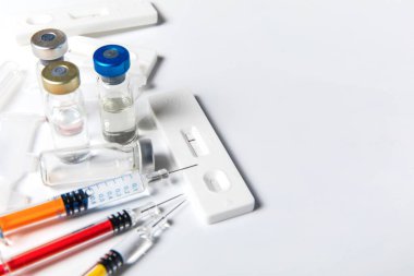 Pozitif SARS-CoV-2 Hızlı Antijen Testi ve şırıngalar. COVID-19 aşısı. Pandemik aşı..