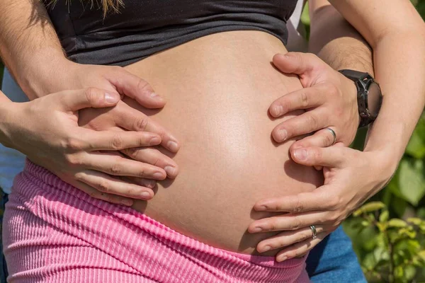 妊娠中の腹と夫婦の手のクローズアップ 妊娠9ヶ月で腹 幸せなカップル — ストック写真