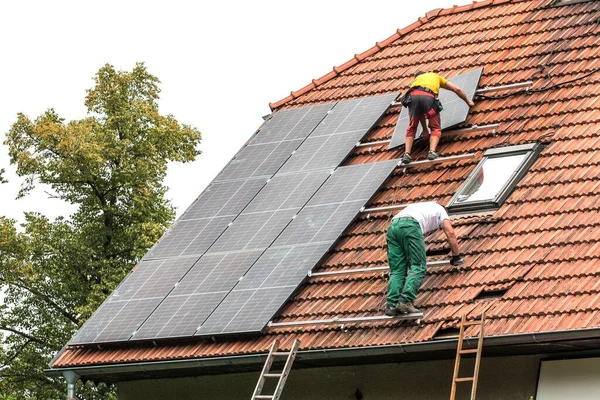 Man Installing New Solar Panels Roof Private House Renewable Energy 免版税图库图片