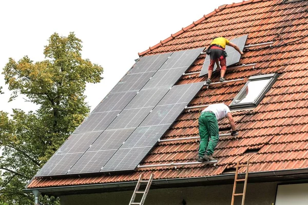 Man Installing New Solar Panels Roof Private House Renewable Energy stockfoto