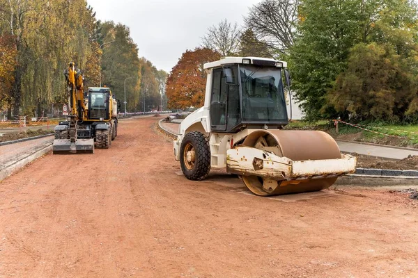 Vibration roller compactor at road construction and repairing asphalt pavement works. Road repair. Construction work.