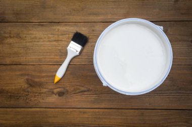 Boya fırçası boyalı bir alet. Boya kovası. Ahşap arka planda boya yapmak için konserve boya.