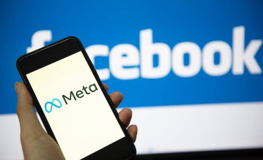 Akıllı telefon ekranında META logosu ve arka planda Facebook logosu var. Yeni Facebook şirketi logosu meta-evren konsepti. Bangkok Tayland, 2 Aralık 2021