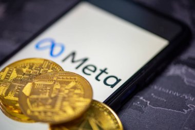 Metaverse sikke konsepti, akıllı telefon ekranında META ve meta logo arka planında altın sikke. Yeni Facebook şirketi logosu meta-evren. Bangkok Tayland, 2 Aralık 2021