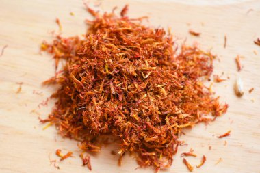 Dried safflower for herbal tea on wooden background, dry safflower petals, Saffron substitute