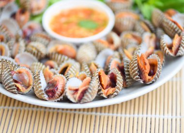 Deniz ürünleri soslu midyeler ve beyaz tabakta sebze salatası, taze çiğ kabuklu deniz ürünleri restoranda deniz ürünleri, deniz kabuklu yiyecekler. 