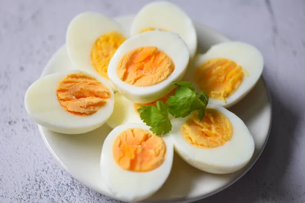 Eggs menu food boiled eggs in a white plate decorated with leaves green coriander, cut in half egg yolks for cooking healthy eating eggs breakfast