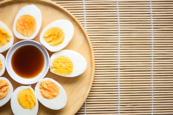 Eggs menu food boiled eggs in a wooden plate with fish sauce, cut in half egg yolks for cooking healthy eating eggs breakfast , top view