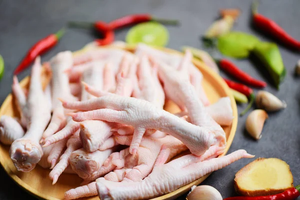 Fresh raw chicken feet for cooked food on the wooden table kitchen background, chicken feet on plate