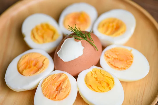 Eggs breakfast, fresh eggs menu food boiled eggs in a wooden plate decorated with leaves green dill background, cut in half egg yolks for cooking healthy eating