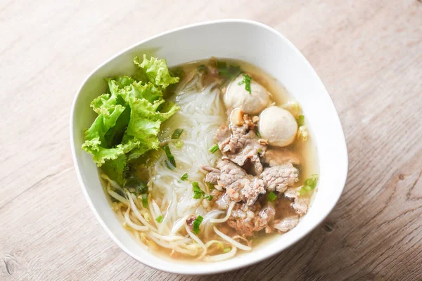 Thai traditional menu food, Noodle soup bowl fresh vegetable lettuce pork and Pork balls on wooden background