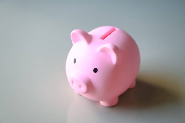 Arka planda domuz kumbarası, eğitim ya da yatırım konsepti için tasarruf yapan pembe domuzcuk bankası.