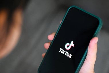 Apple iPhone 13 Pro 'da TikTok uygulama simgesi olan akıllı telefonu elinde tutan çocuk, Çin' den popüler sosyal medya ağında Tiktok logosu simgesi,: Bangkok, Tayland - 3 Haziran 2022