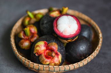 Mangosteen sepeti ve koyu arka planda, taze olgun mangosteen tropikal meyve Tayland yaz aylarında ağaçtan soyulmuş