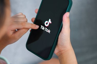 Apple iPhone 13 Pro 'da TikTok uygulama simgesi olan akıllı telefonu elinde tutan çocuk, Çin' den popüler sosyal medya ağında Tiktok logosu simgesi,: Bangkok, Tayland - 3 Haziran 2022