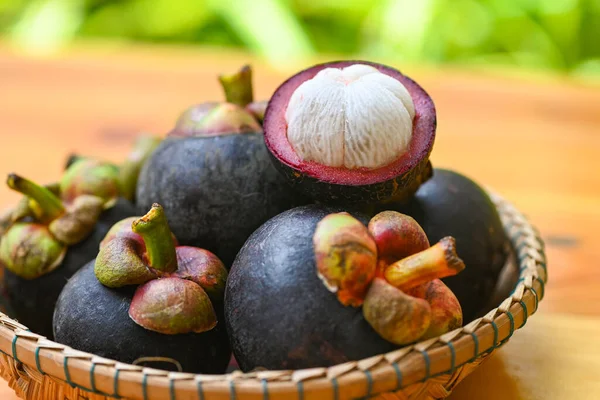 Mangosteen sepet ve ahşap arka planda, taze olgun mangosteen tropikal meyve Tayland yaz aylarında ağaçtan soyulmuş