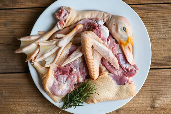 Raw duck breast leg feet wing duck head with spices herb rosemary to cook on white plate, Fresh duck meat for food , poultry meat parts