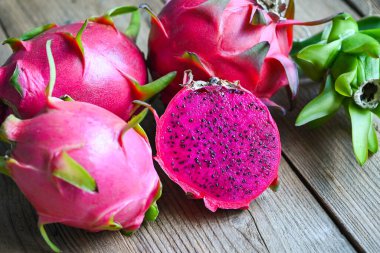 Pembe ejder meyvesinin yarısı pitahaya arkaplanlı, yarısı ahşap, taze ejderha meyvesi Asya Tayland ve sağlıklı meyve kavramında tropikal