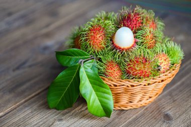 Rambutan meyvesi sepetin arka planında toplanan Rambutan ağacı taze ve olgun tropikal meyveler yapraklı rambutan.