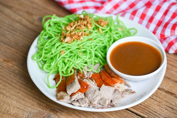 Roasted duck with jade noodle on white plate and duck sauce, green noodles Chinese food, Jade noodle Asian Thailand food