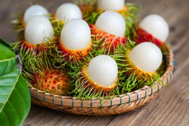 Rambutan fruit harvest from the garden rambutan tree, Fresh and ripe rambutan sweet tropical fruit peeled rambutan with leaf