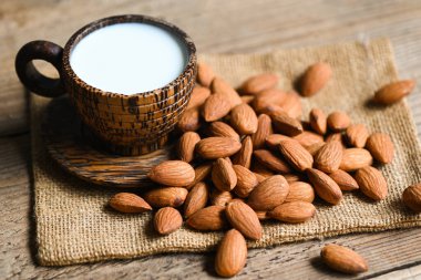 Almond milk and Almonds nuts on on sack background, Delicious sweet almonds on the table, roasted almond nut for healthy food and snack