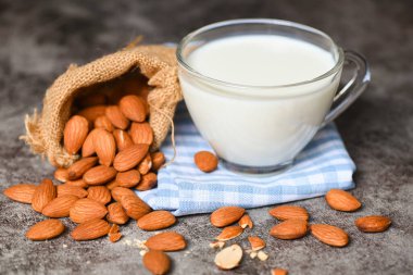 Almond milk and Almonds nuts on on sack background, Delicious sweet almonds on the table, roasted almond nut for healthy food and snack