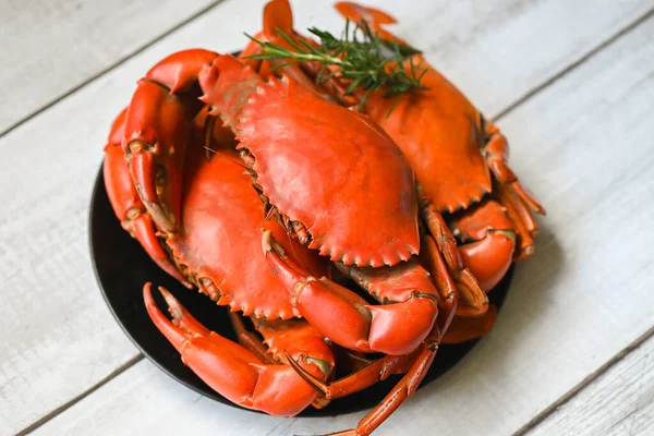 seafood plate with herbs spices rosemary, fresh crab on black plate, crab cooking food boiled or steamed crab red in the restaurant