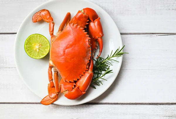 seafood plate with herbs spices rosemary lemon lime, fresh crab on white plate, crab cooking food boiled or steamed crab red in the restaurant 