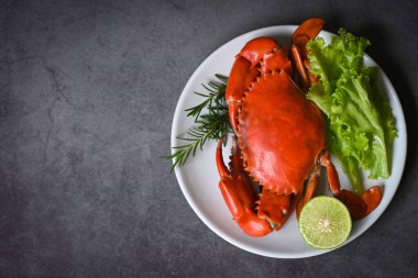 seafood crab cooking food boiled or steamed crab red in the seafood restaurant, fresh crab on white plate dark background - top view