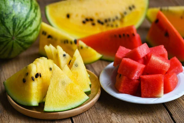Red and yellow watermelon slice on plate and wooden background, Closeup sweet watermelon slices pieces fresh watermelon tropical summer fruit - top view