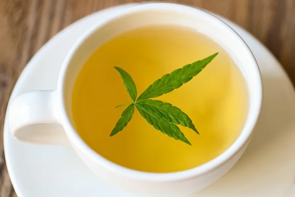 Health tea with hemp leaf plant THC CBD herbs food and medical concept, Cannabis tea herbal on tea cup with cannabis leaf marijuana leaves herb