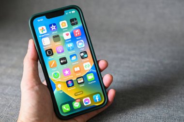 iOS 16 logolu iPhone, iPhone Apple cihazlarında 2022-2023 yeni işletim sistemini kapatın alt sürüm ios 16 ekran adam eli iPhone: Bangkok, Tayland - Eylül 2022 