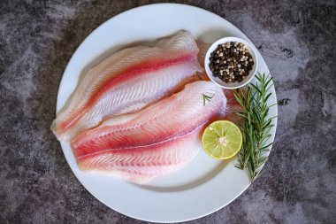 Bitki ve baharatlı taze pangasius balığı filetosu limon ve biberiye, et doli balık tilapia çizgili yayın balığı, balık filetosu ve yemek için malzemeler - üst görünüm 