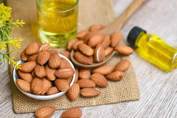 Roasted almond nut for healthy food and snack organic vegetable oils for cooking or spa concept, Almond oil and Almonds nuts on bowl, Delicious sweet almonds oil in glass bottle
