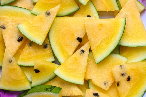 Yellow watermelon slice on background, Closeup pile of sweet watermelon slices pieces fresh watermelon tropical summer fruit - top view