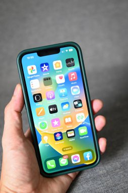 iPhone 'un iOS 16 logosuna sahip iPhone, iPhone Apple cihazlarındaki 2022-2023 işletim sistemini kapatın ios 16 ekran adam eli iPhone: Bangkok, Tayland - Eylül 2022 