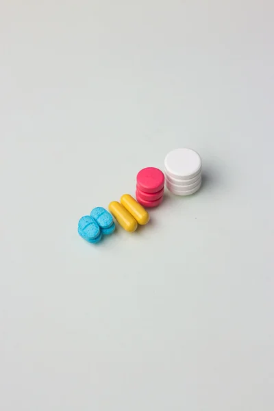 Pilha de cápsulas e comprimidos isolados sobre fundo branco — Fotografia de Stock