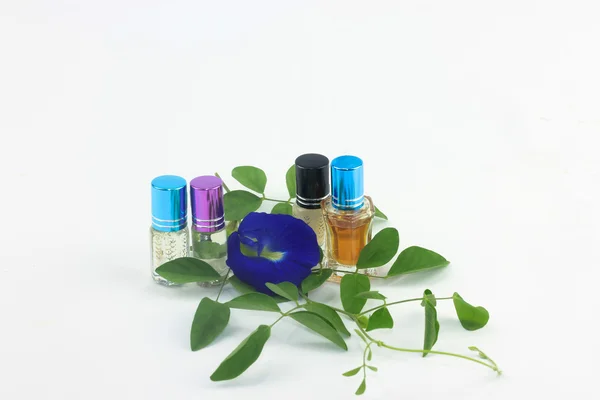 Botellas de perfume y flores aisladas sobre fondo —  Fotos de Stock