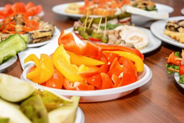 Kırmızı domates ve sarı dolma biber, bir tabakta istiflenmiş.