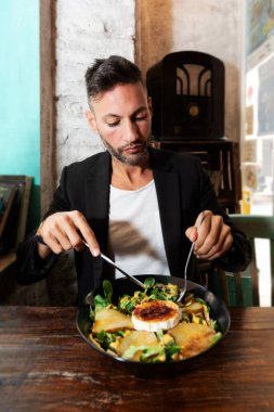 Şehir barında salata yiyen genç bir vejetaryen. Yüksek kalite fotoğraf