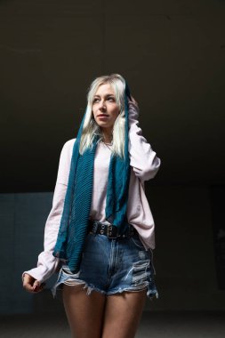 Zarif, sakin, atkısı olan güzel, sarışın bir kadın. 