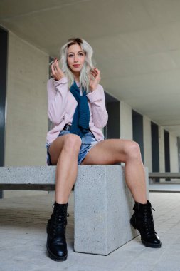 Modayı takip eden genç sarışın bir kadın üniversitede takılıyor.