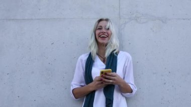 Çıkmak. Genç bir kadın cep telefonuyla sohbet ederken arkadaşlarıyla gülüyor.